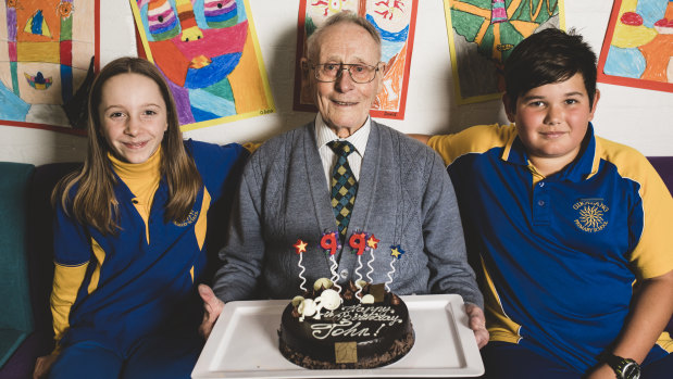 Rat of Tobruk John Fleming celebrates his 99th birthday on Friday with Giralang Primary School captains Selima Macadam and Shae Pressley, both 11.