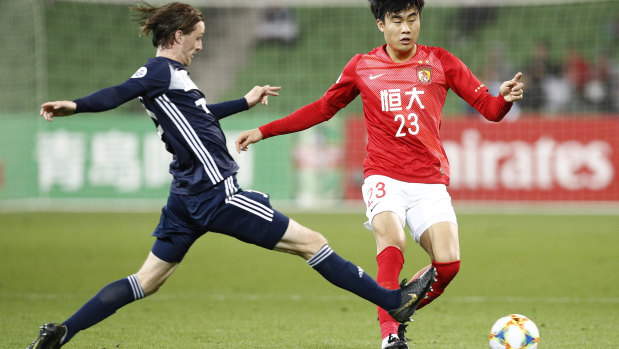 Park Jisu of Guangzhou Evergrande passes the ball under pressure.