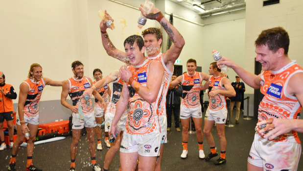 Downpour: Greater Western Sydney players celebrate their first win over the Crows in Adelaide.