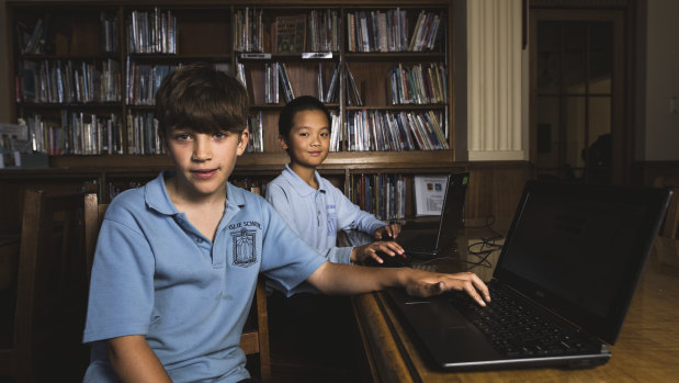 Ainslie School Year 5 students (front) Ned Bonyhady 9, and (behind) Max Ai, 10, practice their NAPLAN test online.