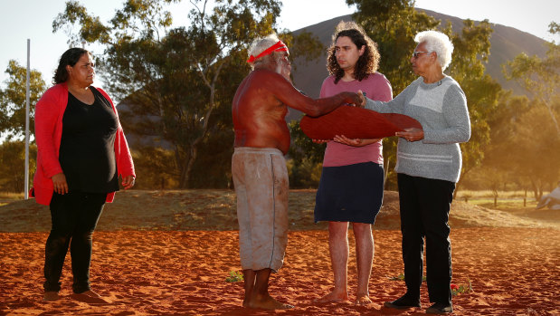 Mutitjulu elder Rolley Mintuma presents the Uluru Statement inside to Teangi Brown and Irene Davey during the closing ceremony, May 2017.