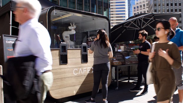 A robotic arm serves up coffee at Cafe X's downtown San Francisco kiosk.