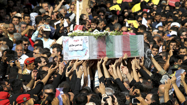 Mourners carry a casket during a mass funeral for those who died in a terror attack on a military parade in the southwestern city of Ahvaz, that killed 25 people attend a mass funeral ceremony, in Ahvaz, Iran.