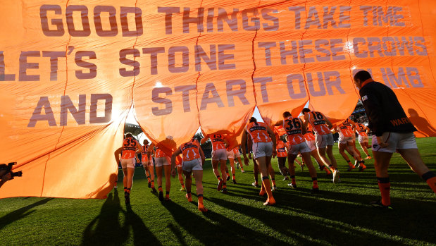 On message: GWS players run through the banner to start their round 11 clash against Adelaide.