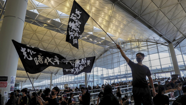 Protesters wave flags at the Hong Kong International Airport.