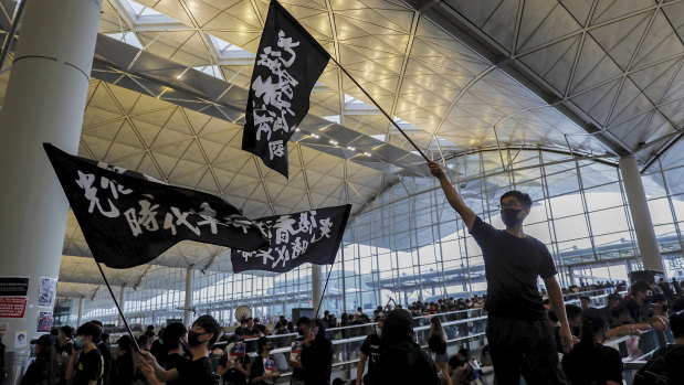 Protesters wave flags at Hong Kong International Airport.