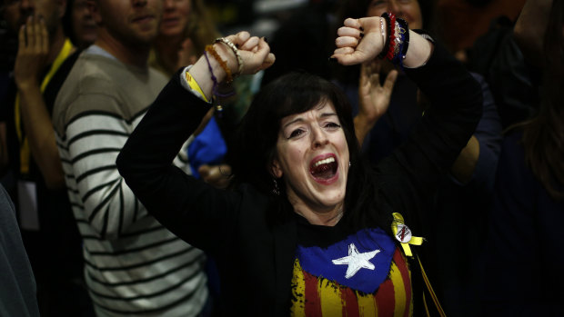 A woman wearing an "estelada" or independence flag reacts to the European election results in Barcelona.