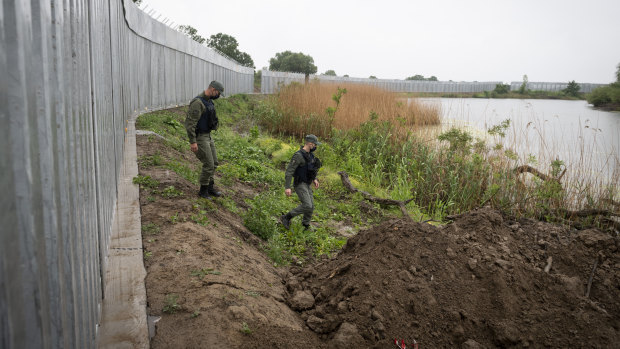 Enhancing the human oversight: police officers patrol alongside a steel wall at Evros river, near the village of Poros, at the Greek -Turkish border.
