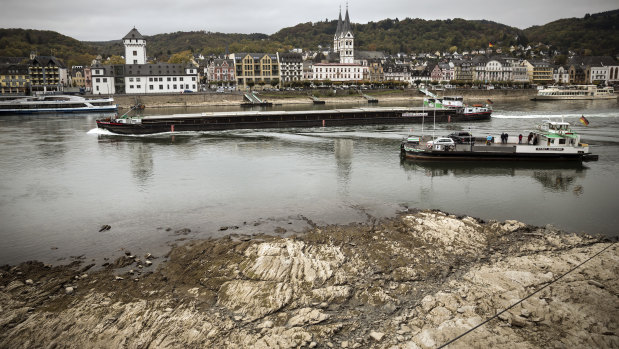 A freighter and ferry pass near rocks visible on the Rhine in Boppard, Germany.