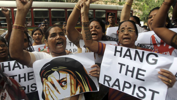 Indian activists hold placards demanding rapists be hanged.