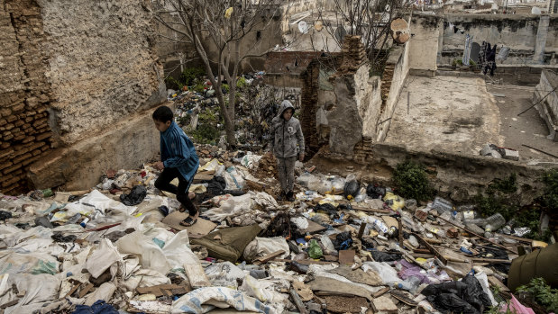 Teenagers climb over rubbish in a vacant lot in the Casbah district of Algiers.