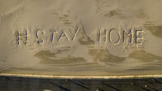 An empty Bondi Beach, closed due to social distancing rules, with the words "Stay Home" on Sunday morning.