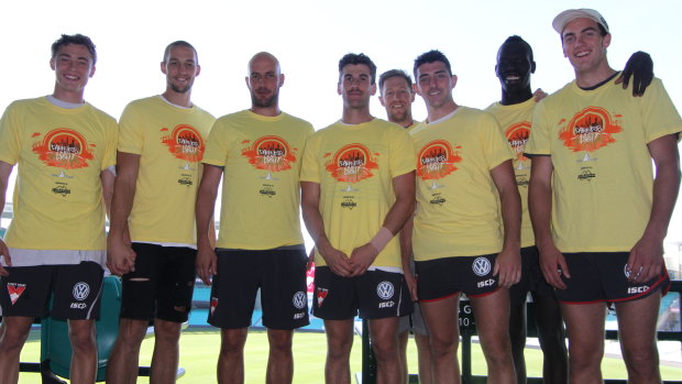 Darkness into Light Sydney ambassador Tadhg Kennelly (third from left) at the SCG last week alongside Sydney Swans (from left) Will Hayward, Sam Reid, Robbie Fox, Jeremy Laidler, Colin O'Riordan, Aliir Aliir and Tom McCartin all sporting the yellow Darkness into Light shirts.