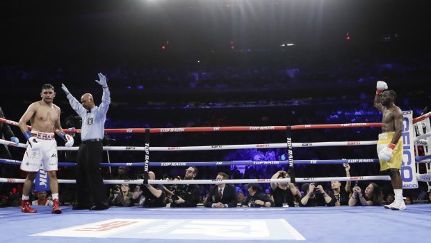 Over and out: The referee stops the fight during the sixth round when Amir Khan could not continue after a low blow by Terence Crawford.
