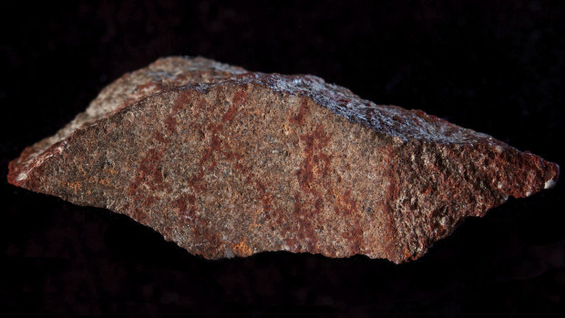 A drawing made with ochre pigment on silcrete stone, found in the Blombos cave east of Cape Town, South Africa. 