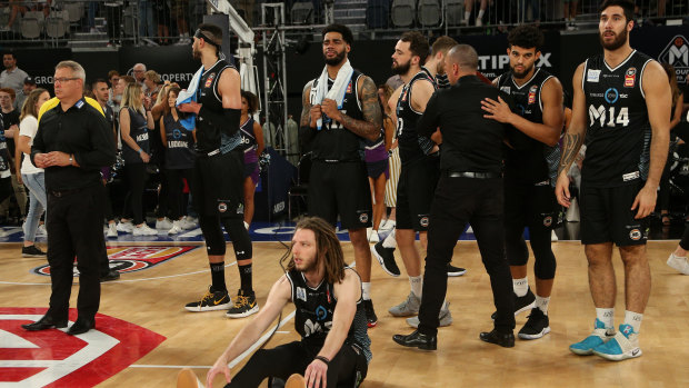 Blow out: Shattered Melbourne players and coach Dean Vickerman (far left) after their loss to new title holders Perth in game four of the NBL grand final series.
