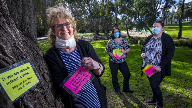 Lee Smith-Moir and daughters Tai (centre) and Cassie with her feel-good messages at Cruickshank Park in Yarraville. 