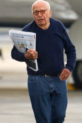 Rupert Murdoch, clutching copies of Fairfax Media's Sydney Morning Herald and Australian Financial Review, stretches his legs at Sydney Airport as his jet is refuelled.