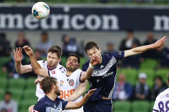 Tough contest: Perth's Bruno Fornaroli, centre, heads the ball against James Donachie. 