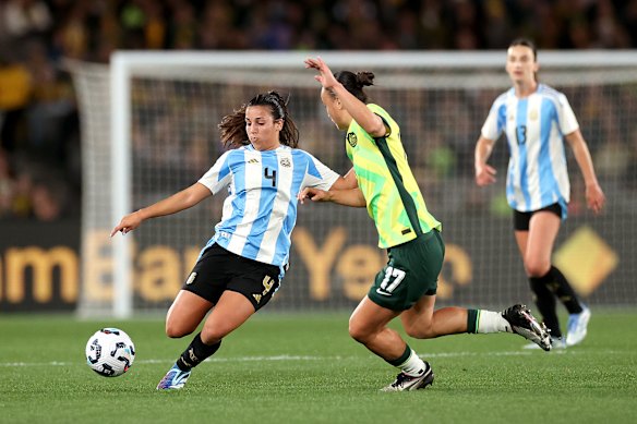 Catalina Roggerone of Argentina kicks the ball against Amy Sayer of Australia.