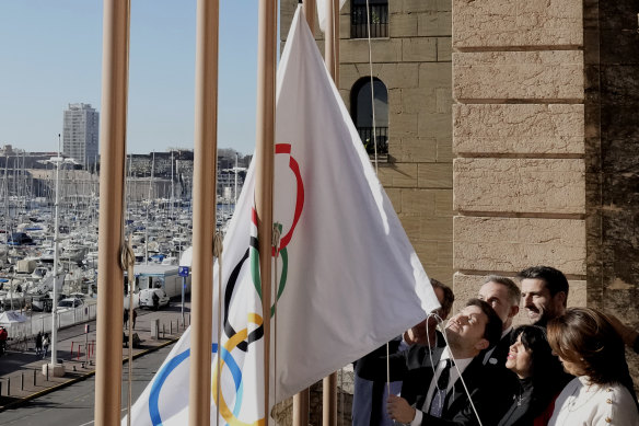 Mayor of Marseille Benoit Payan, centre, raises the Olympic flag with Head of Paris 2024 Olympics Tony Estanguet, centre right, after a press conference at the Marseille City Hall, southern France.