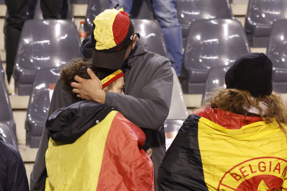 A supporter is comforted on the stands after suspension of the soccer match between Belgium and Sweden at the King Baudouin Stadium in Brussels. 
