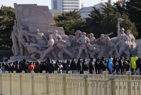 People queue in front of revolutionary statues as they wait to get into Mao Zedong’s mausoleum.