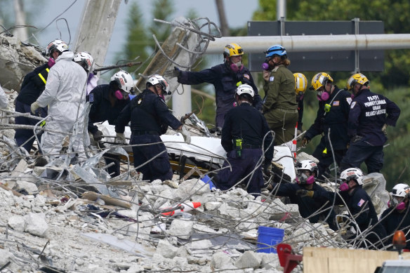 Rescue workers move a stretcher containing recovered remains at the site of the collapsed Champlain Towers South after the remaining structure was demolished.