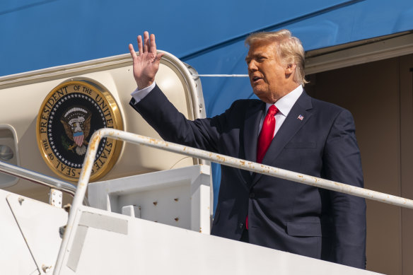 Donald Trump waves as he disembarks from his final flight on Air Force One at Palm Beach International Airport on Wednesday.