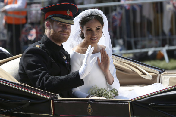 Prince Harry and Meghan ride in an open-topped carriage after their wedding ceremony in May 2018.