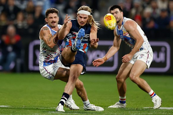 Bailey Smith clears the ball despite a tackle from Tom Liberatore.