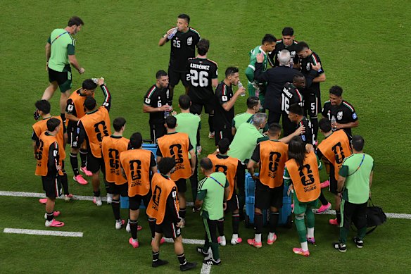 Javier Aguirre speaks to his team during the hydration break.
