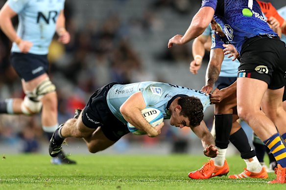 Waratahs Lewis Creighton is tackled by Rieko Ioane of the Blues.