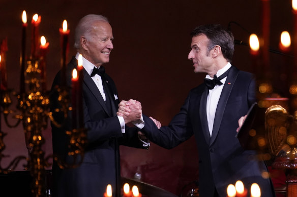 President Joe Biden and French President Emmanuel Macron shake hands before a toast during a state dinner at the White House.