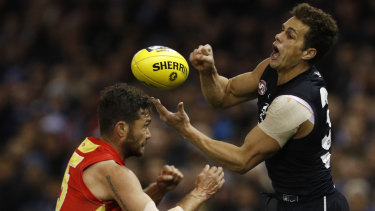 Carlton's Ed Curnow gets a handball away under pressure.
