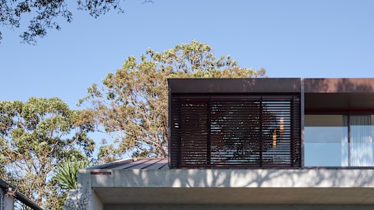 The home responds to the land’s contours, a 25-degree fall from the street.