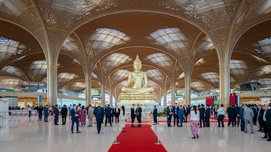 A golden nine-metre serene Buddha statue in the Abhayamudra pose symbolising peace and protection, greets all.