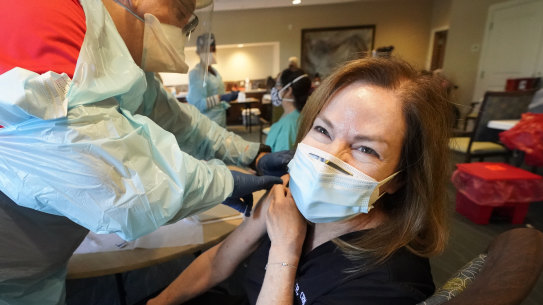 Healthcare worker Pam Peter, right, prepares to receive her second round of the COVID-19 vaccine, Wednesday, Jan. 6, 2021, at John Knox Village in Pompano Beach, Fla. Ninety residents and 80 staff members received their second shot of the vaccine Wednesday and 50 new staff members received their first round of the vaccine. (AP Photo/Wilfredo Lee)