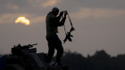 An Israeli soldier Stans on a tank as it is taking position in front of the northern Gaza Strip.