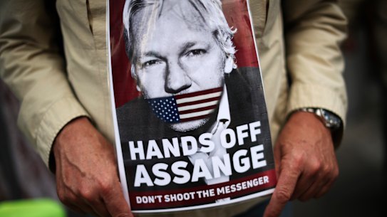 A man holds a photograph of WikiLeaks founder Julian Assange during a protest in Brussels demanding he be freed.