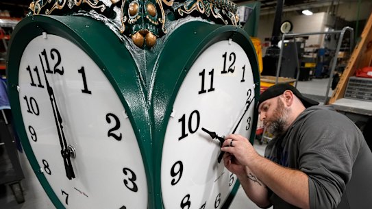 Clock technician Dan LaMoore adjusts a large outdoor clock under construction in Medfield, Massachusetts.