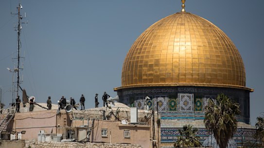 Israeli police stand on a rooftop near Al-Aqsa mosque.