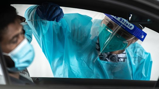 A health worker carries out a COVID-19 testing at the Merrylands drive-through clinic in Sydney.