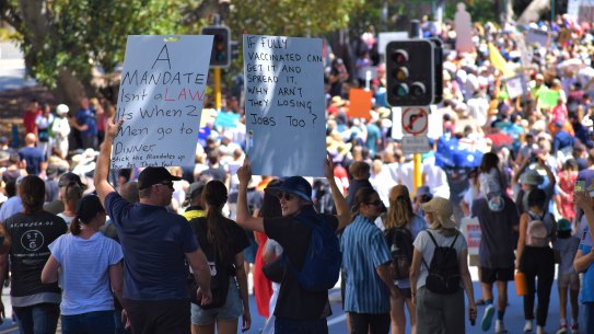 People march through Perth’s CBD holding signs and calling out the word “freedom” in protest of vaccine mandates and strict borders. 