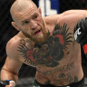 Conor McGregor of Ireland punches Dustin Poirier in a lightweight fight at the Etihad Arena in Abu Dhabi in 2021.