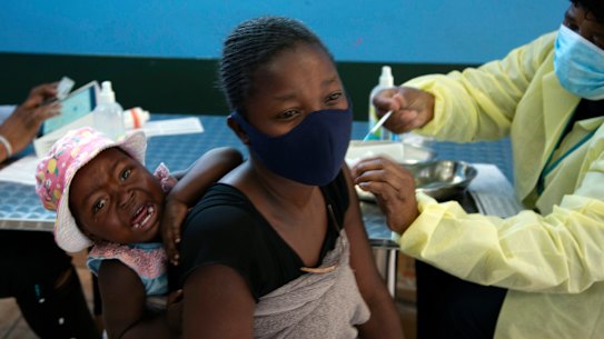 A baby cries as her mother receives her Pfizer vaccine against COVID-19, in Diepsloot Township near Johannesburg. A new COVID-19 variant has been detected in South Africa.
