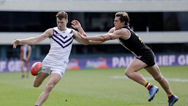 Blake Acres of the Dockers kicks the ball.