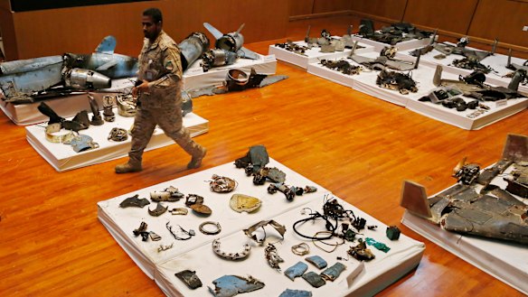 A Saudi military officer walks by what was described as the remains of Iranian cruise missiles and drones used in an attack that targeted the heart of Saudi Arabia's oil industry. 