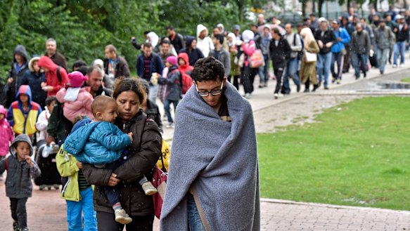 Migrants walk from the main station in Dortmund, Germany, to a hall at the height of the migrant crisis in 2015.