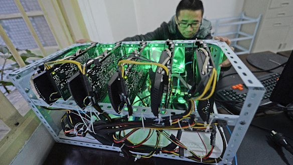 A staff member checks a bitcoin mining computer at the bitcoin mining company Landminers in southwestern China’s Chongqing Municipality.